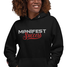 Load image into Gallery viewer, Woman wearing black "Manifest Success" hoodie with stylish lettering, promoting a mindset of achievement and empowerment.